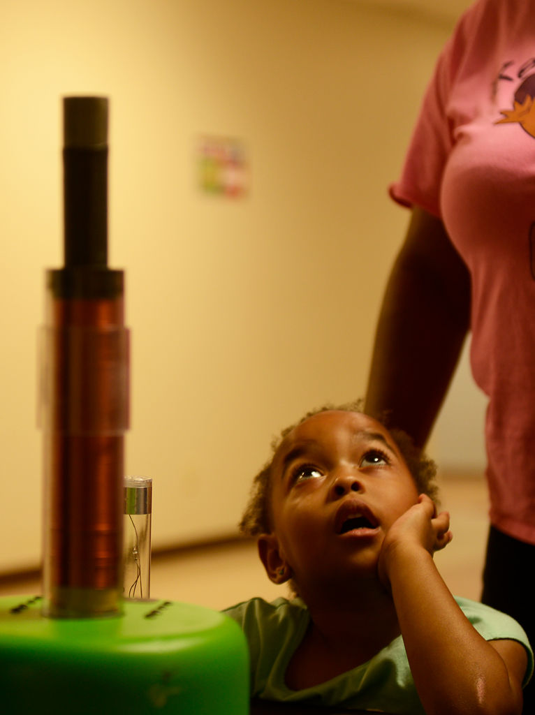 Iiyana Finner, 3, watches a metal ring repelled into the air